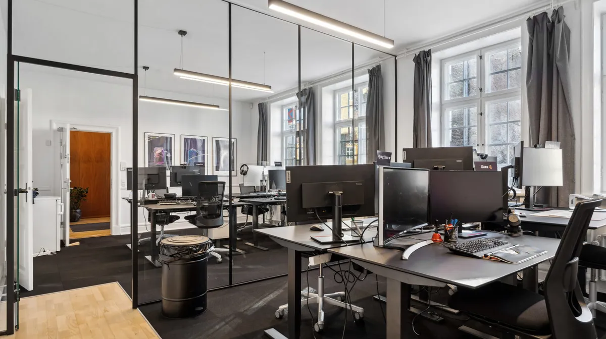 Moderne kontorlokaler med højloft, højkvalitetsmøbler og teknologi samt fire store vinduer og lyse loftslamper i Nedergade