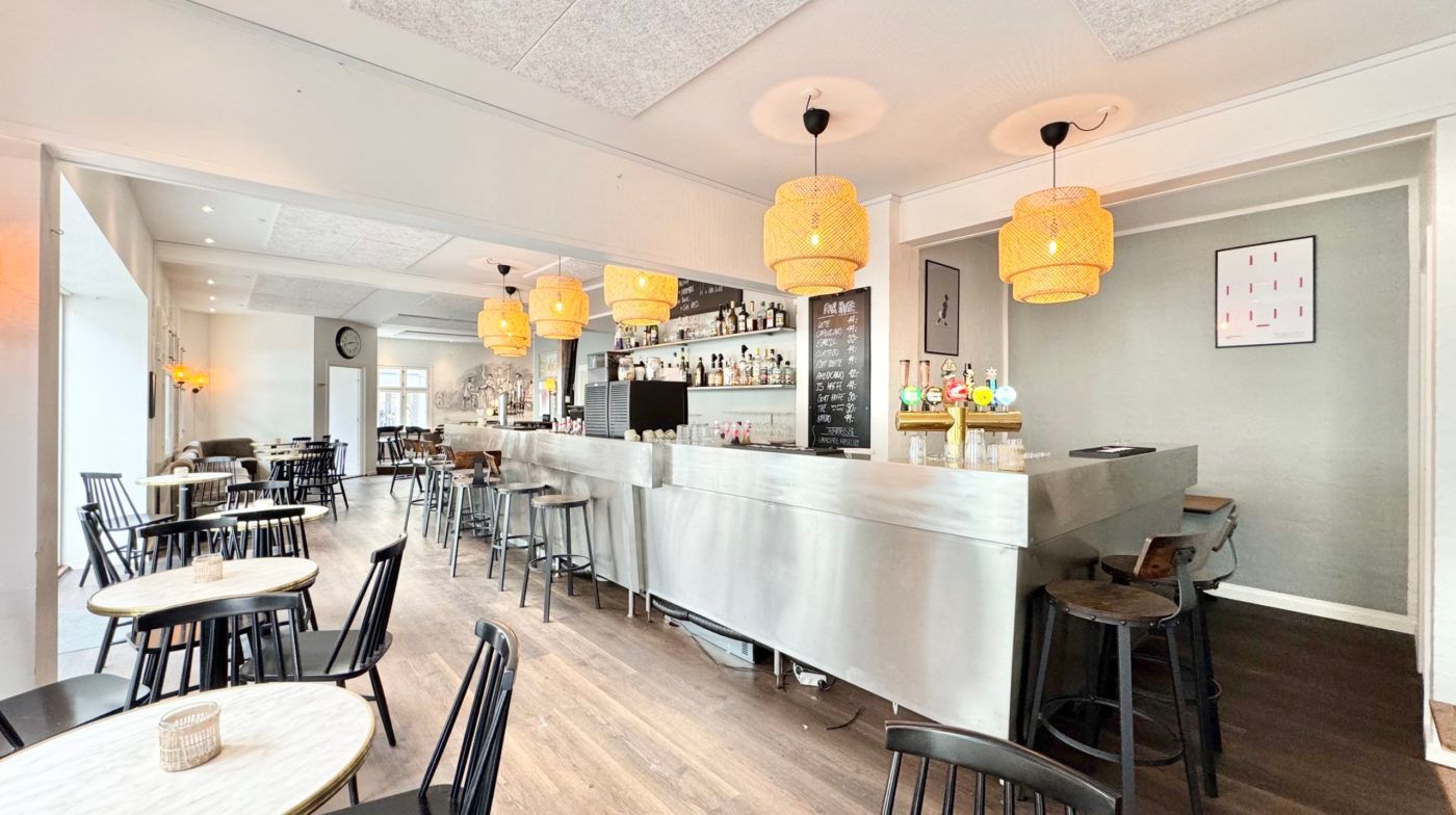 Interiør med baren og møbler, der inkluderer stolpe og stol, gulvbelægning og loft.