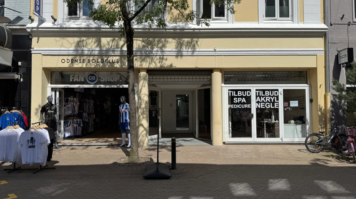 Kvindemanequin i OB-trøje og to hanemanequins i OB-skjorte foran fanbutik. Spa- og pedicure-lokal med mange vinduer og