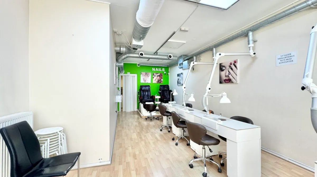 Et veludstyret og pænt neglesalon med højt til loftet, der tilbyder neglepleje og manicure. Loftet er hvidt og har en