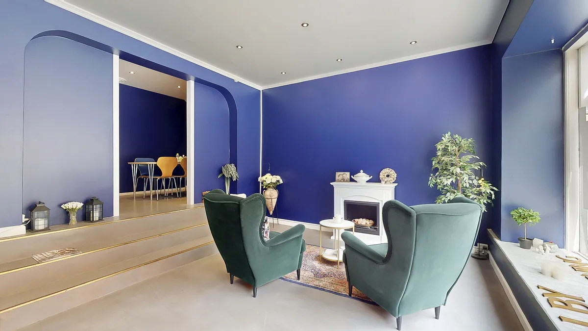 To grønne lænestol i stuen med gulvbelægning og indretning med møbler, plante og ildsted med kakkelovn og skab