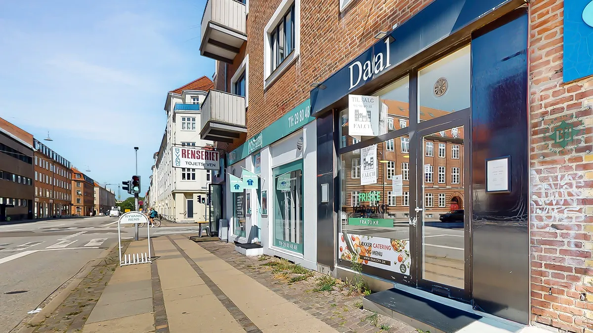 En gård med en forretning med navnet Dalal og en annonce i vinduet om madleverancer