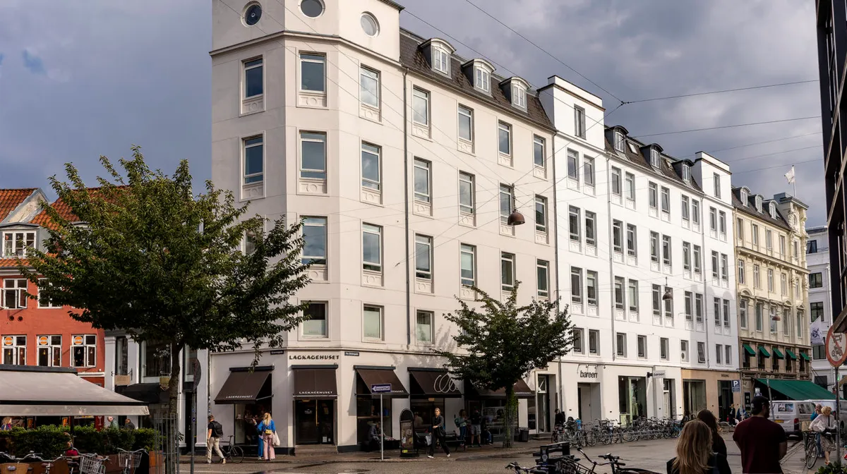 Store butikslokaler med mærket Lackagehuset samt BarEen i Ny Østergade i København. Foran er gågade med folk, cykler og træer