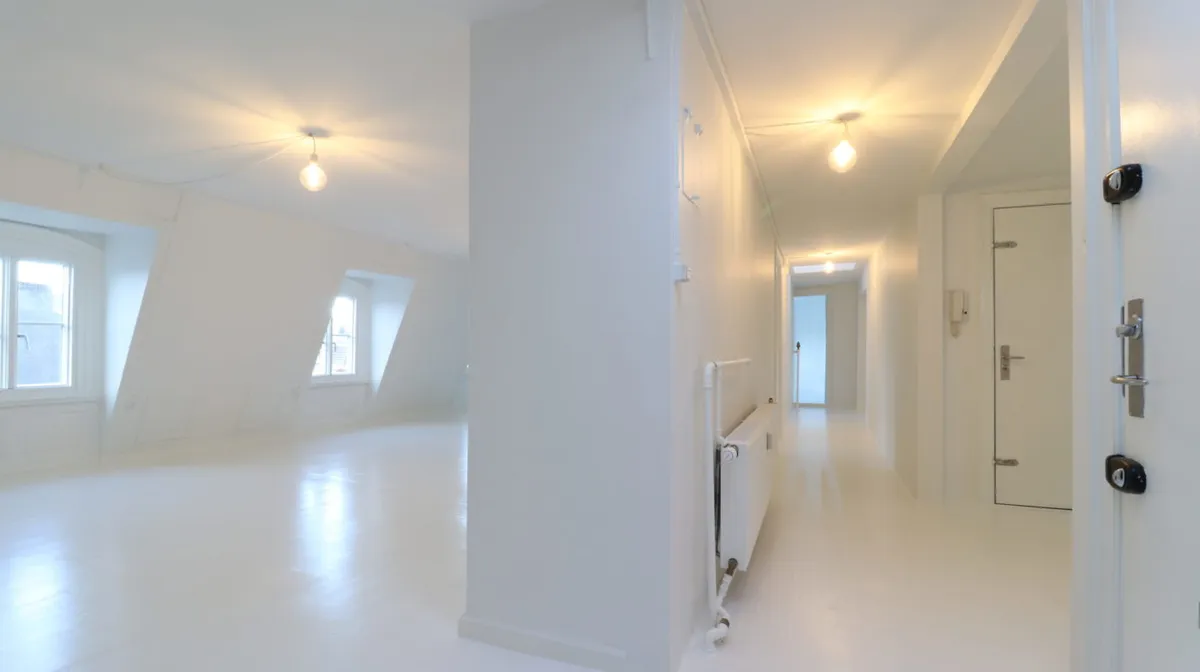 Værelse med hvide vægge og loft, lysekroner og lysepunkter samt radiator, der står ved siden af en hvid stige
