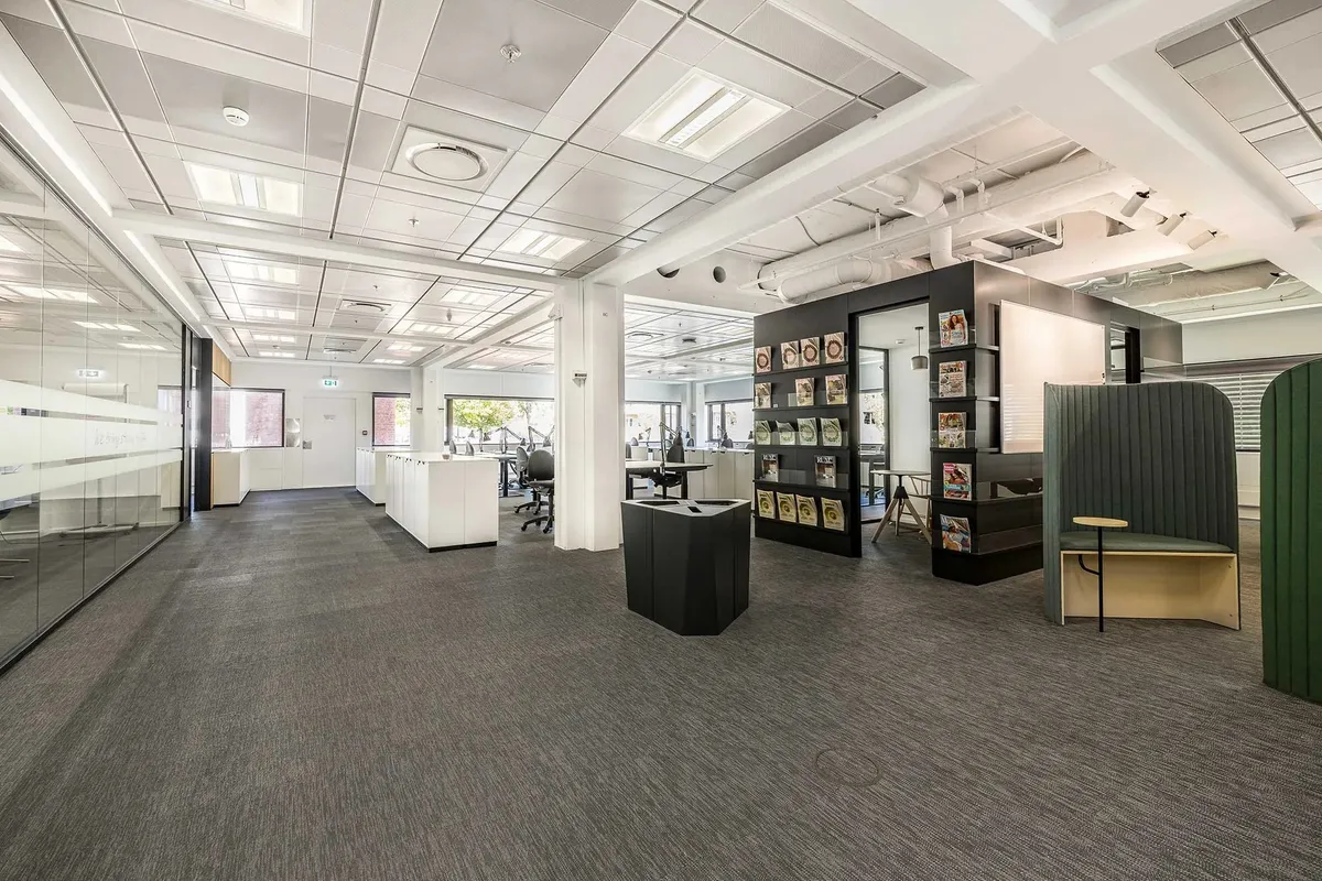 Kontor med højt loft, moderne møbler, højt teknologisk udstyr og flotte gulve i en moderne indretning