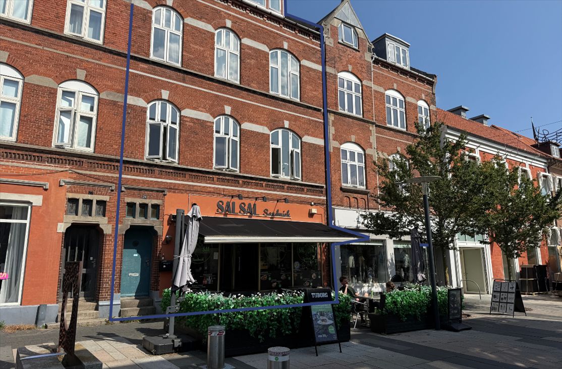 Et rødt murstenshus med vinduerne og guldfarvede indramninger og en restaurant med navnet Salsa på den gule facade og et