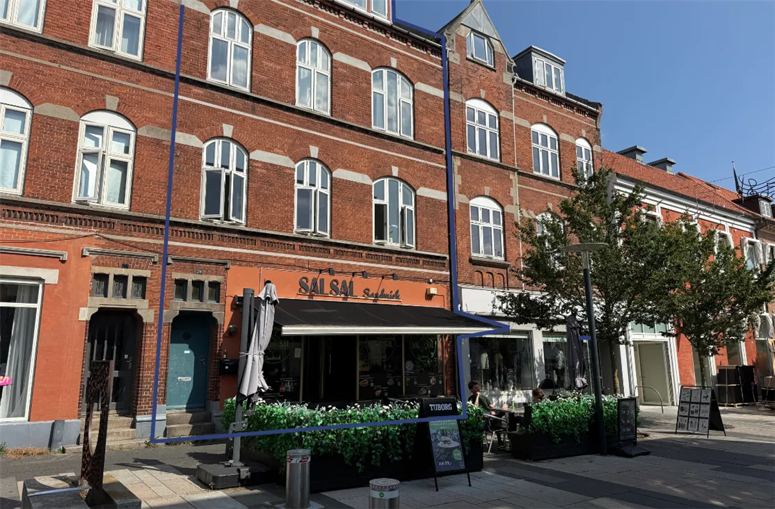 Et rødt murstenshus med vinduerne og guldfarvede indramninger og en restaurant med navnet Salsa på den gule facade og et