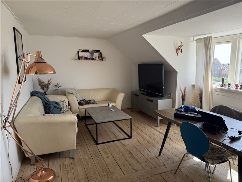Elegant indretning med hvidt loft og gult gulv, luksuriøs sofa og tv, forgyldt lampe og moderne møbler