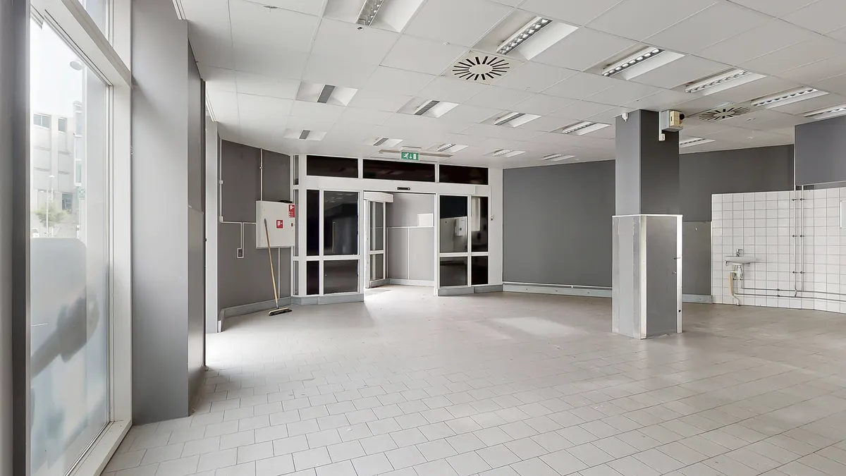 Lokal med glasvinduer og tøjvask til leje. Rummelige lokaler med hvide fliser og store vinduer. Moderne indretning med lyse,