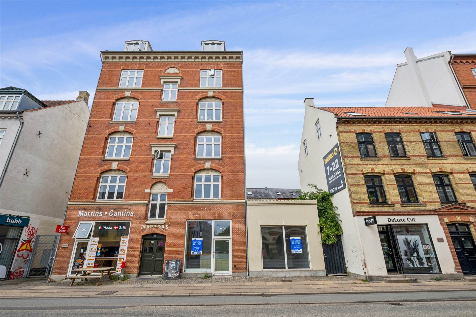 Butikslokaler med facaden udsmykket af vinduerne, der vender ud mod gågaden med forretninger som Martins Cantina og DeLuxe
