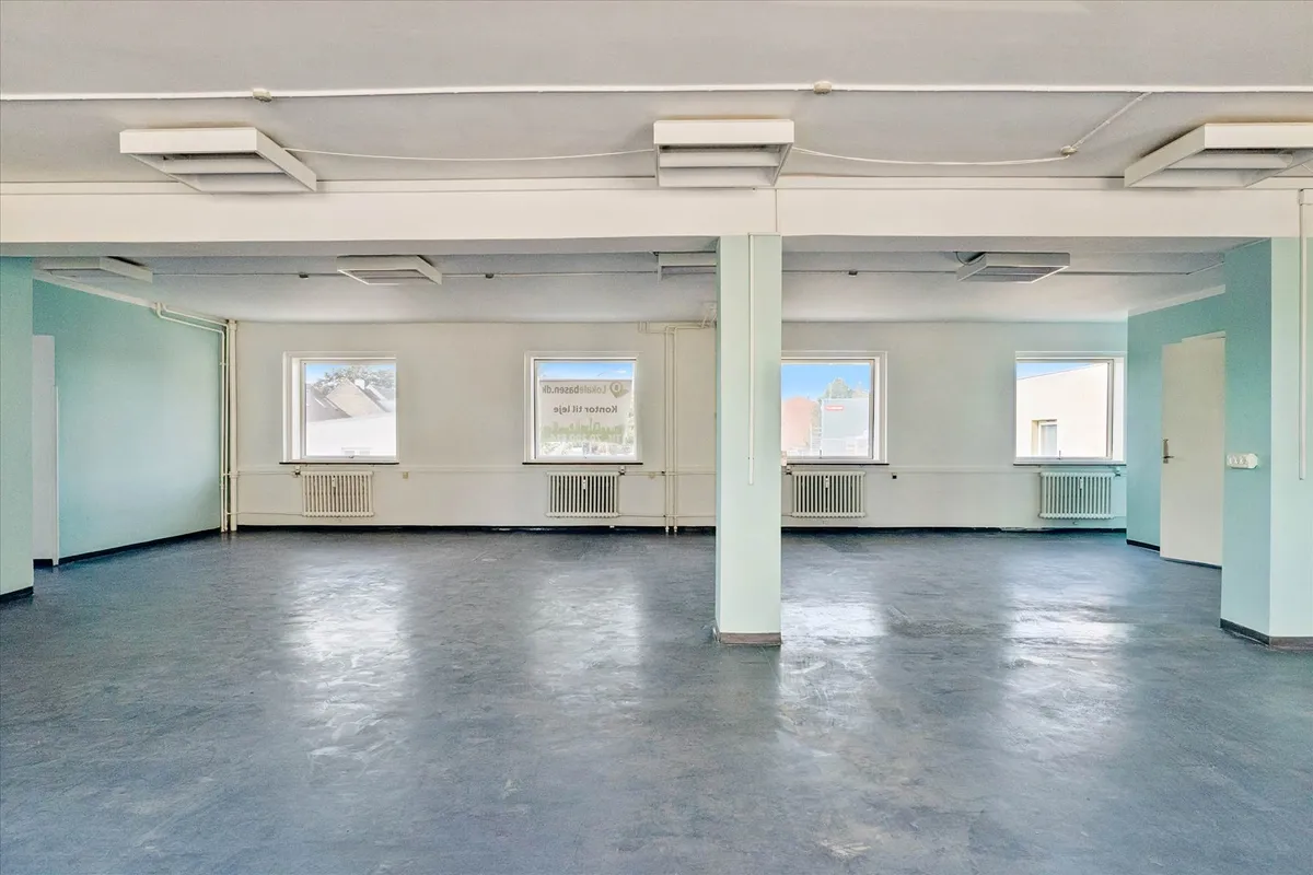 Et glasdækket kontorlokale med tre vinduer og en dør, hvor hver væg er malet i en blå og hvid farve.