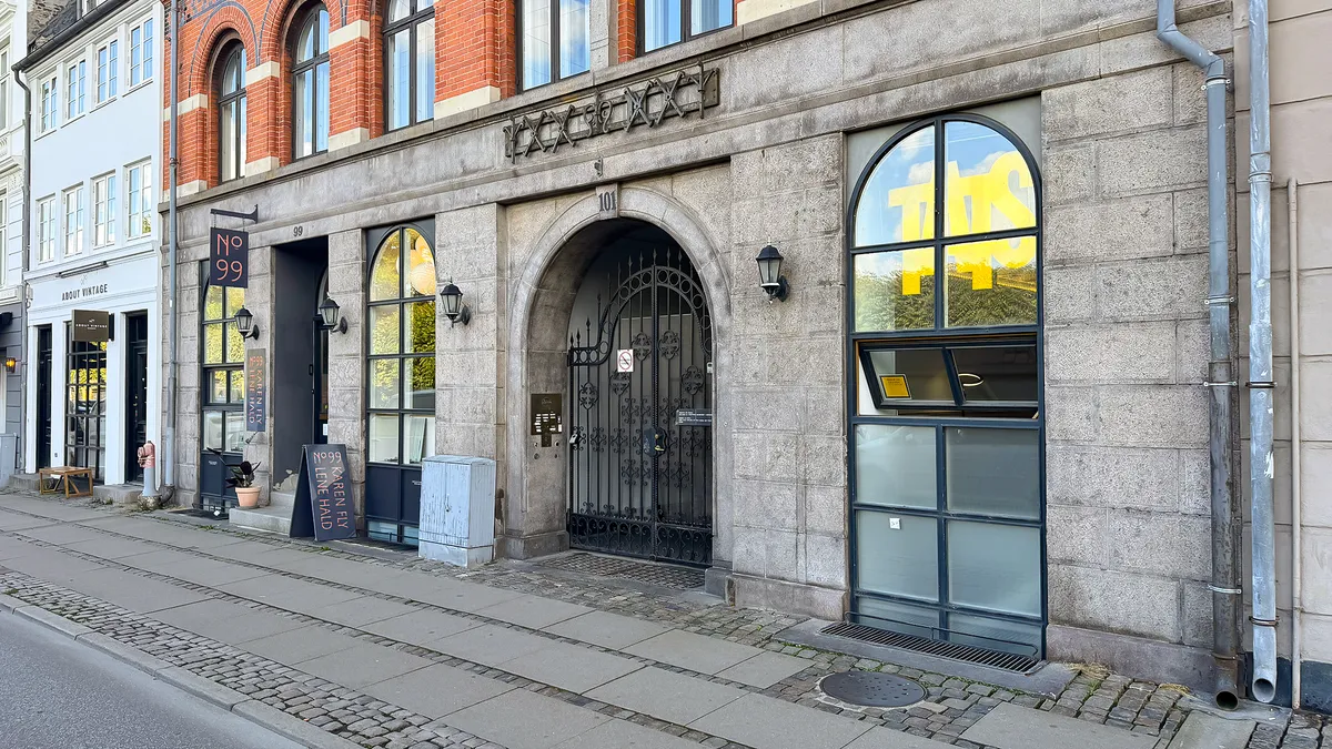 Et kontorlejemål med vinduer og en stor glasdør og en møntautomat udenfor, der er beliggende i Gothersgade 101