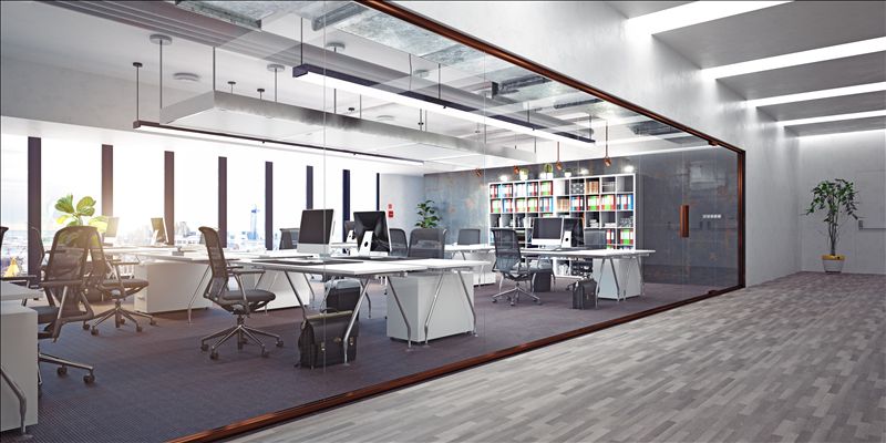 Glasvæggede kontorrum med skriveborde og stole. Der er to bøjle, hvor der er hængt to monitorer og en computer. En plante i