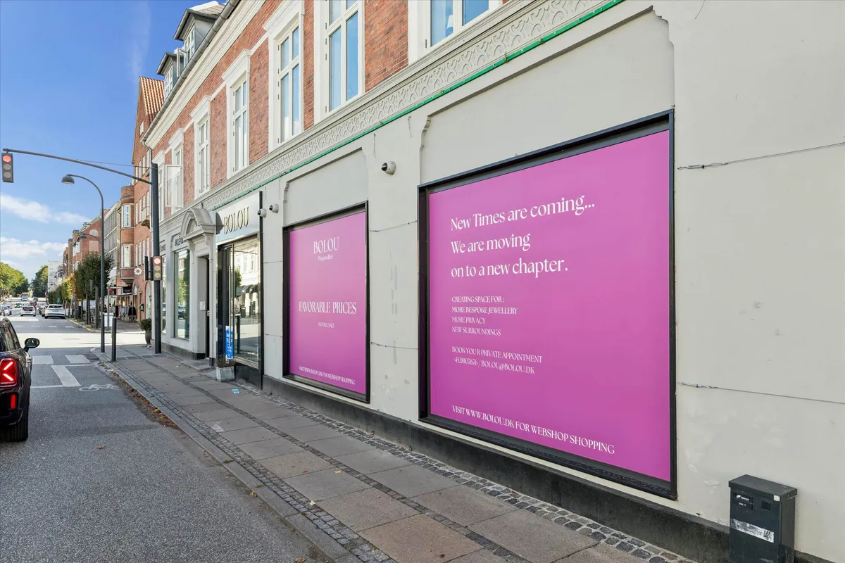 Butik med pink reklameskilt og teksten New Times are coming, vi er moving on to a new chapter.