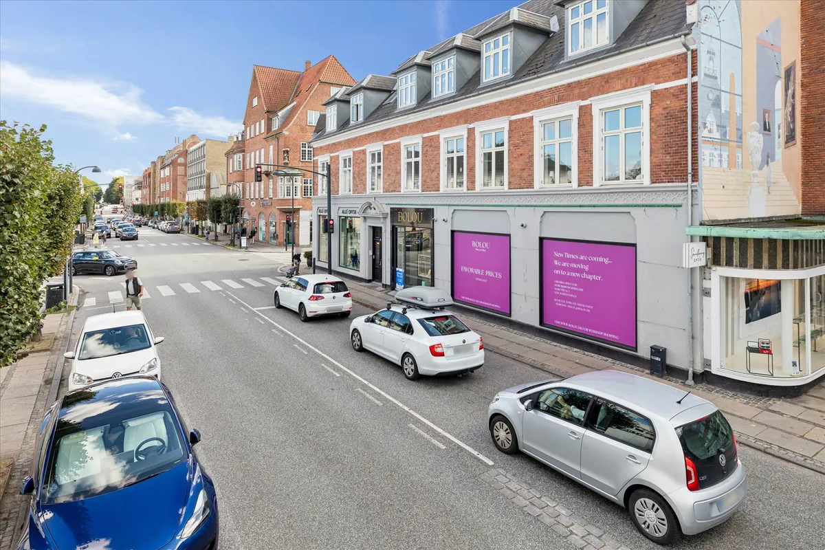 Billede af Bolu butikslokaler og biler, der kører forbi på Jægersborg Allé, med folk, der går på fortovet