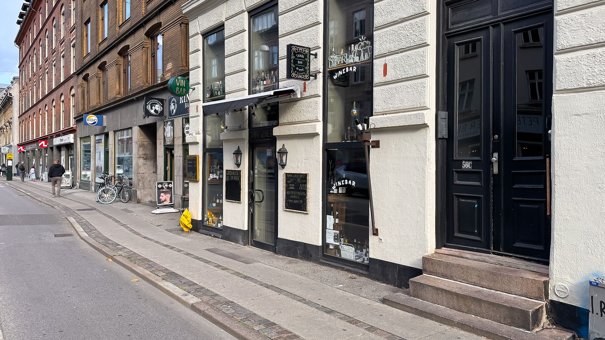 Butiksvindue med udskæring "Vin Bar" og udstilling af flasker og etiketter i vinbaren i København