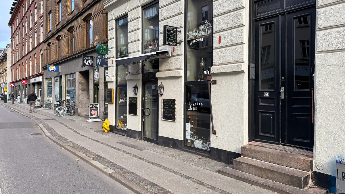 Butiksvindue med udskæring "Vin Bar" og udstilling af flasker og etiketter i vinbaren i København