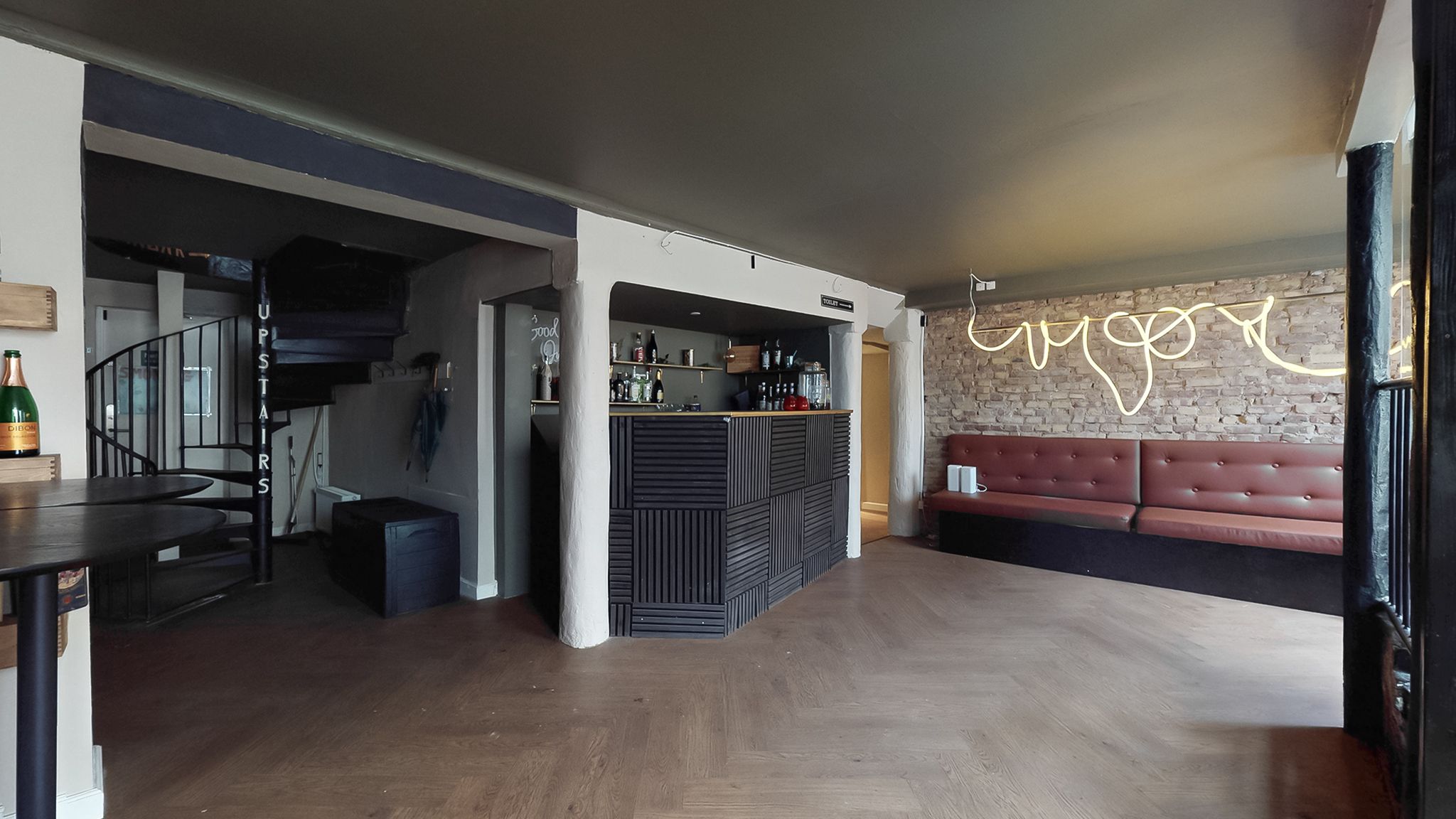 Store lokaler med marmorgulv og lyse vægge, høj kælder og et skab med champagneflasker og glas