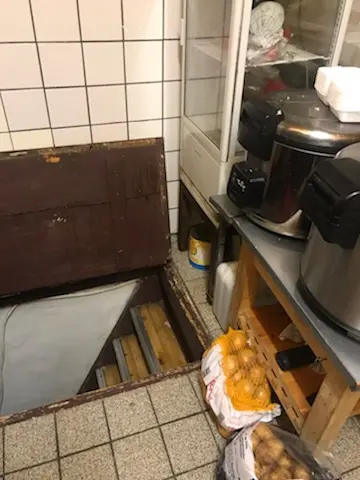 Åbne kasse med stiger ned i gulvet i køkken i en Take-Away forretning