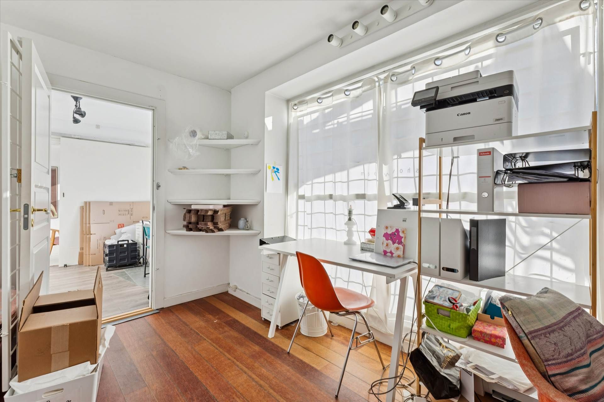 Studielejlighed med højloft og højt til loftet, hvor lysevinduer og lysegulve præsenterer en minimalistisk og funktionel