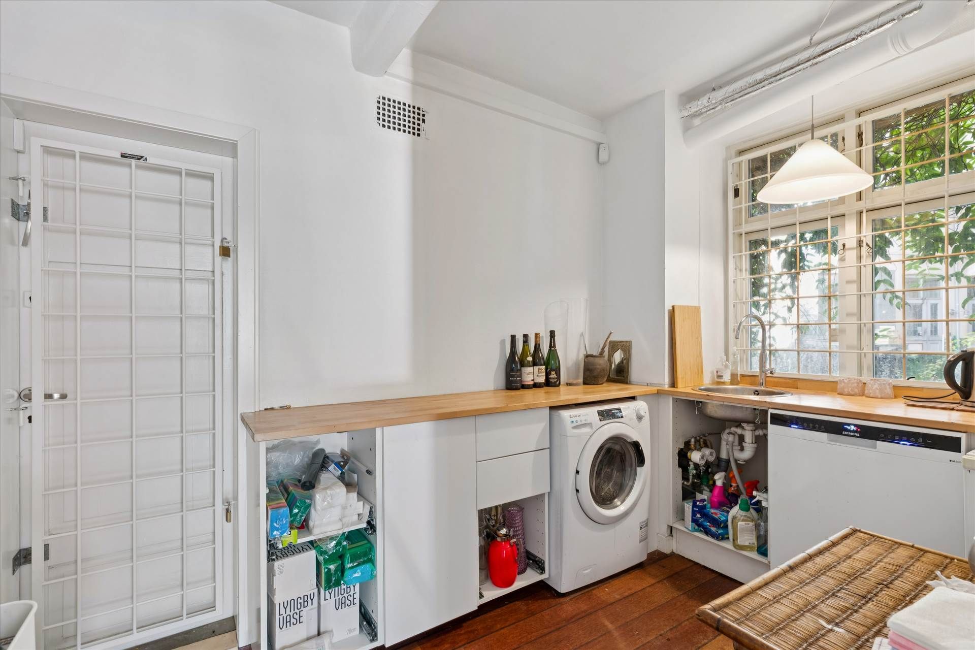 En hvid vaskeri med lyse trægulve og højt loft, med lyse buer og flere vinduespartier