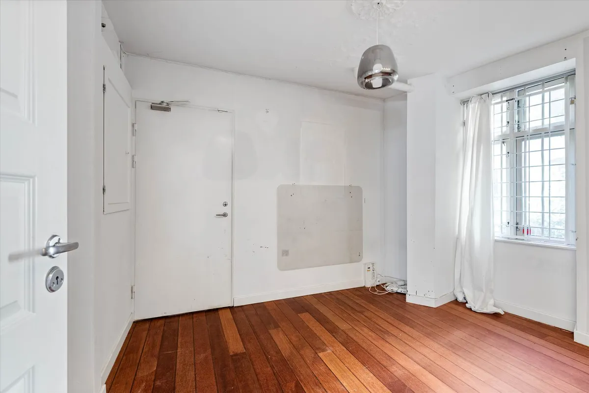 Ledig lokale med højt til loftet, hvide vægge, trægulv og store ruder mod gaden. Lokalet er ubeboet og er fordelt på 1 etage.