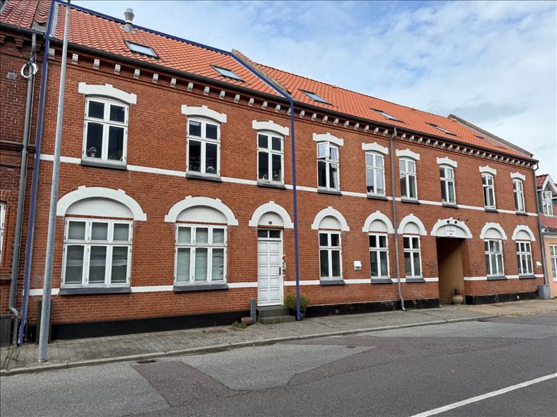 Store røde lejlighedsbygninger med mange vinduer og hvide omrammede vinduer i Sundegade