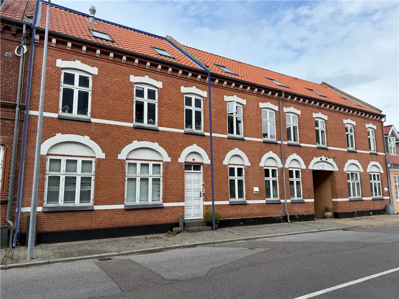 Store røde lejlighedsbygninger med mange vinduer og hvide omrammede vinduer i Sundegade