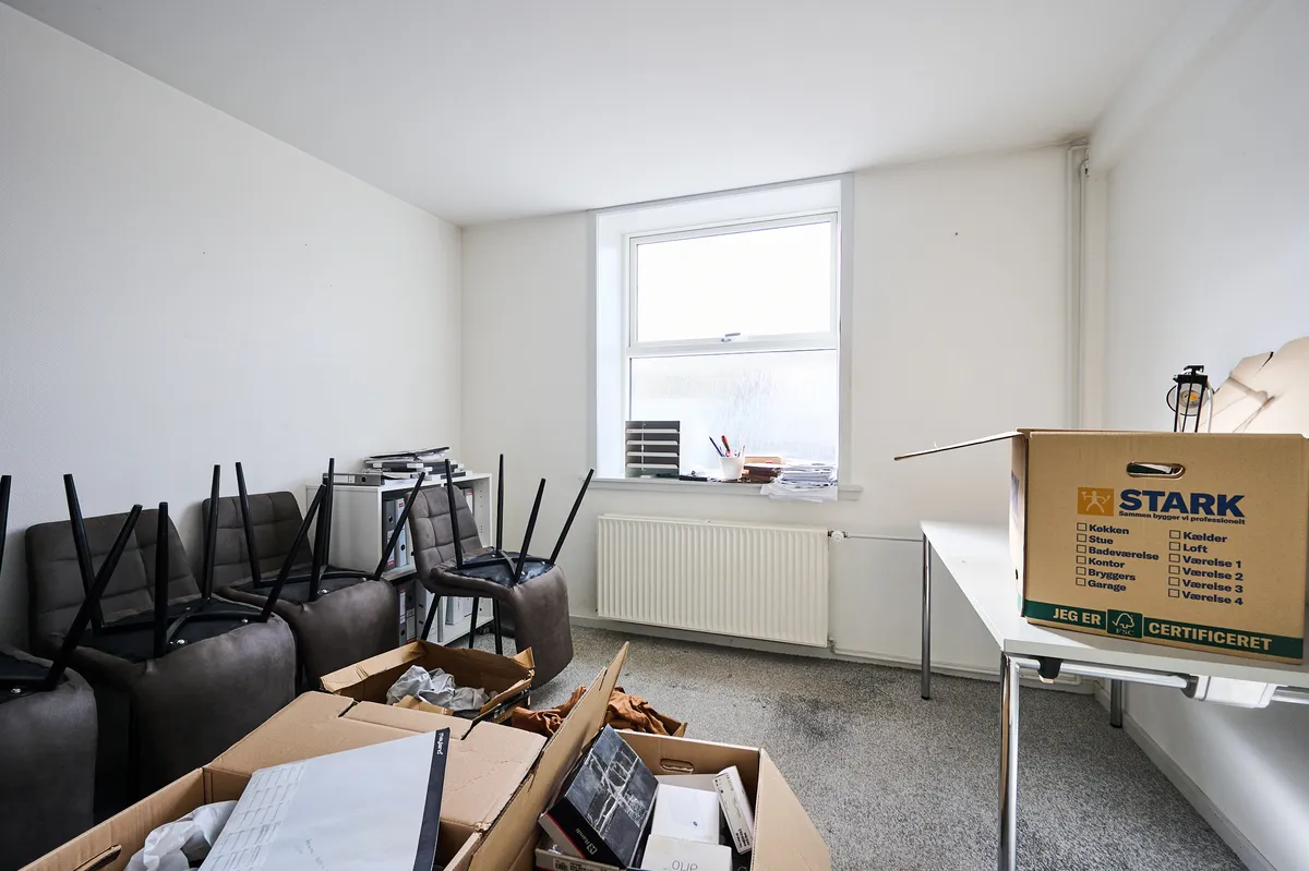 Møbler og bokse i en tom rum, hvor det er muligt at pakke og transportere ting