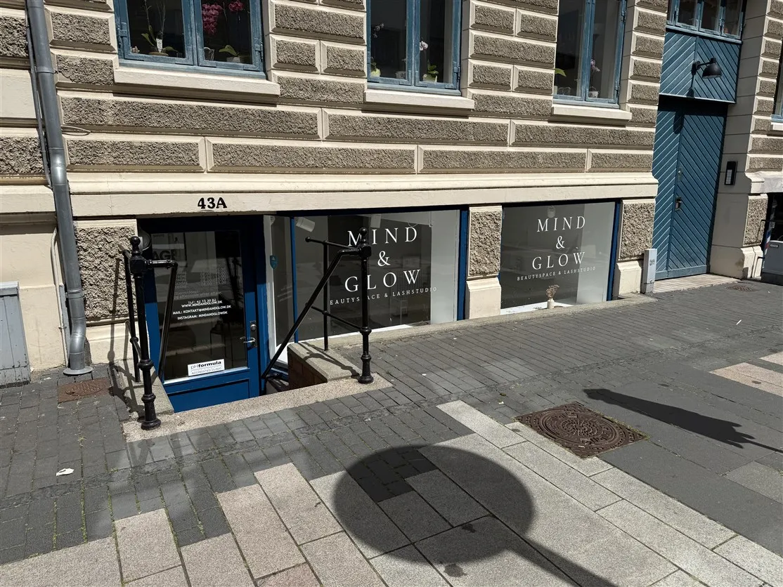 Mind & Glow ligger på 43A, og de tilbyder beauty og lash studio. Der er smukke vinduer med blomster, og der er en dør med