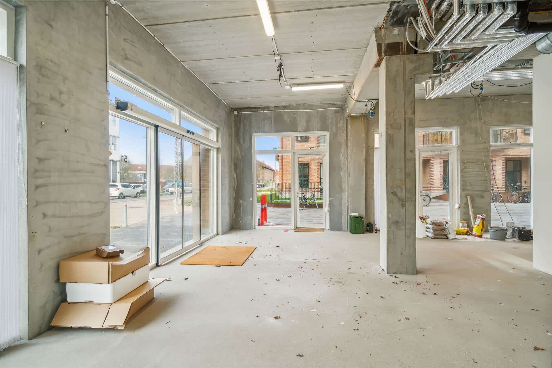 En nyopført erhvervsenhed med hjørnebeliggenhed, store vinduer og udgange, samt skur og parkeringsplads til leje