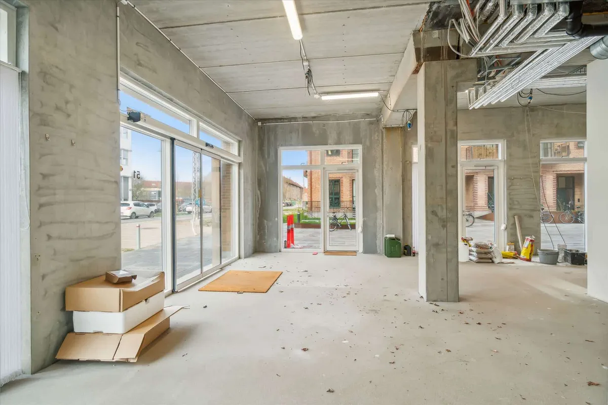 En nyopført erhvervsenhed med hjørnebeliggenhed, store vinduer og udgange, samt skur og parkeringsplads til leje