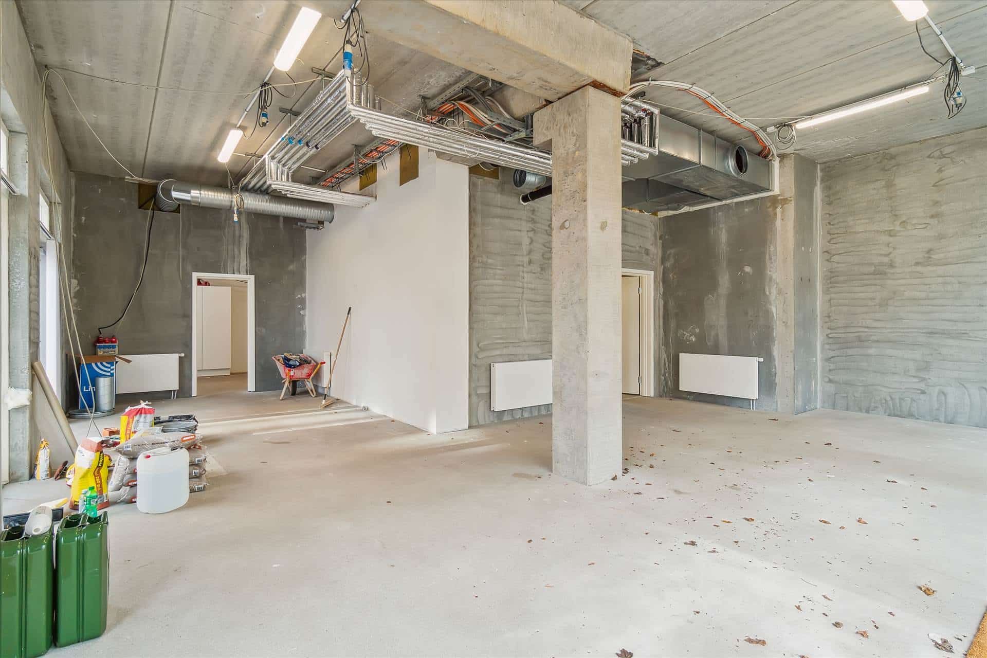 Byggested med hjørnebeliggenhed, hvor mange materialer og redskaber er placeret på gulvet