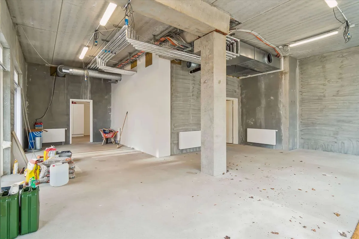 Byggested med hjørnebeliggenhed, hvor mange materialer og redskaber er placeret på gulvet