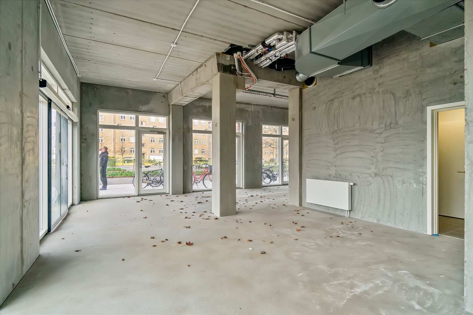 Store lokaler med glasvinduer og højt til loftet og røde cykler parkeret udenfor