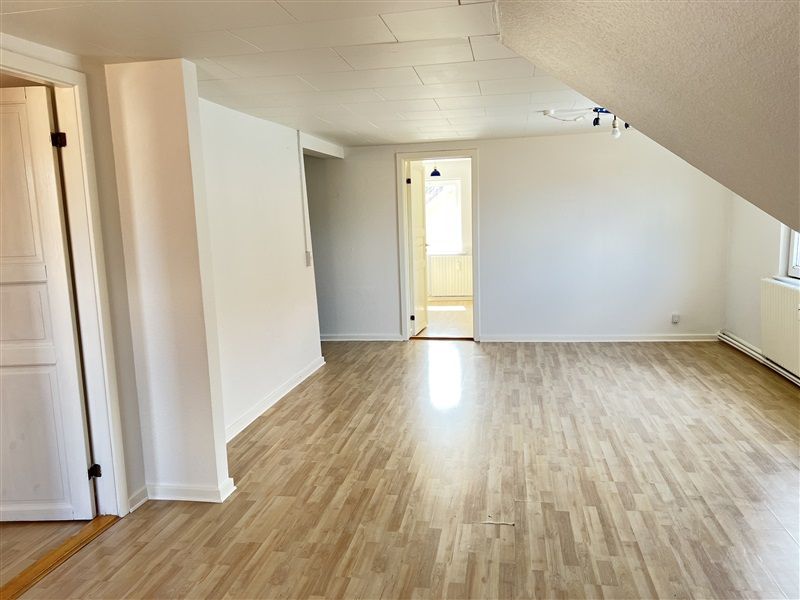 Tomt værelse med lysegul gulvbelægning og hvide vægge uden møbler og dekorationer