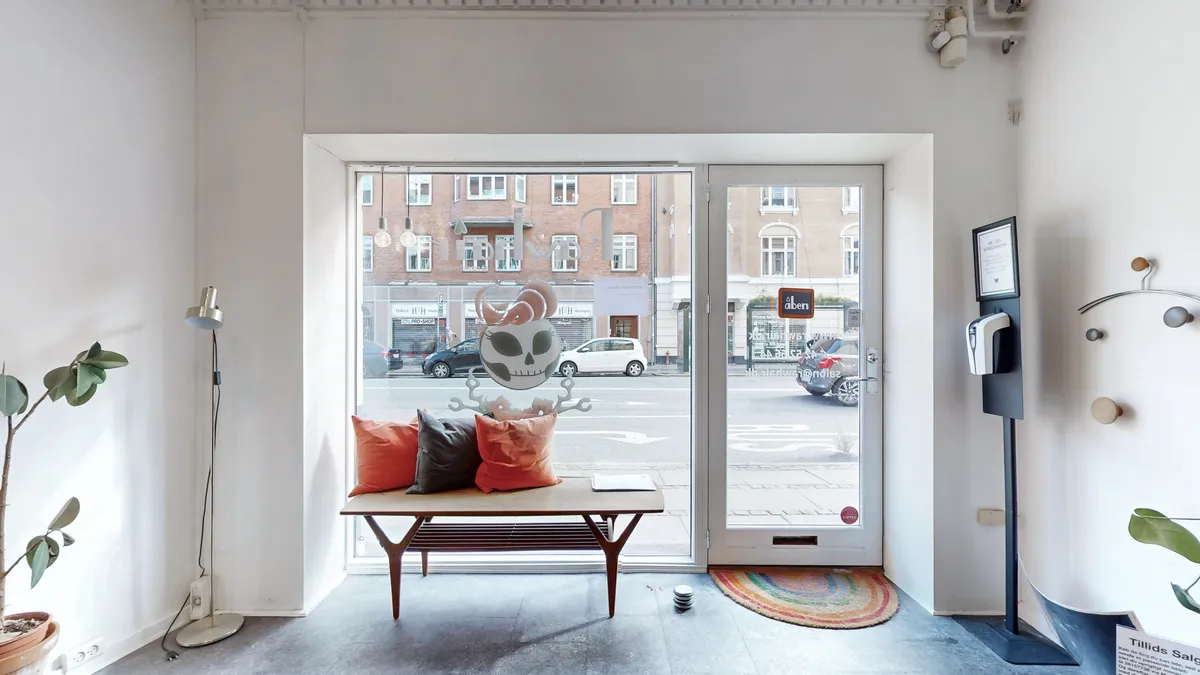 Indvendigt smukke lokaler med møbler og dekorationer samt vinduer med udsigt til gaden og kørende biler