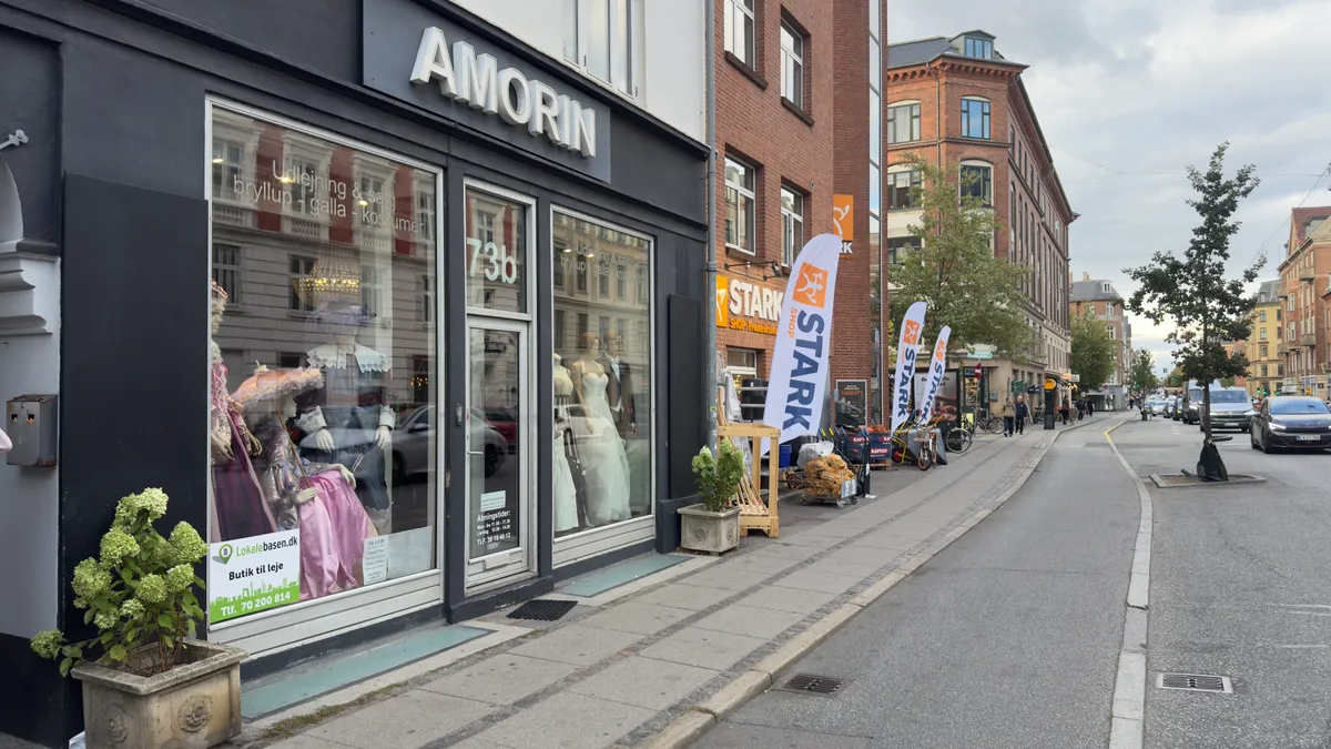 Vej med butikker, hvoraf Amorin og Stark har store udsalgsvinduer og flag foran