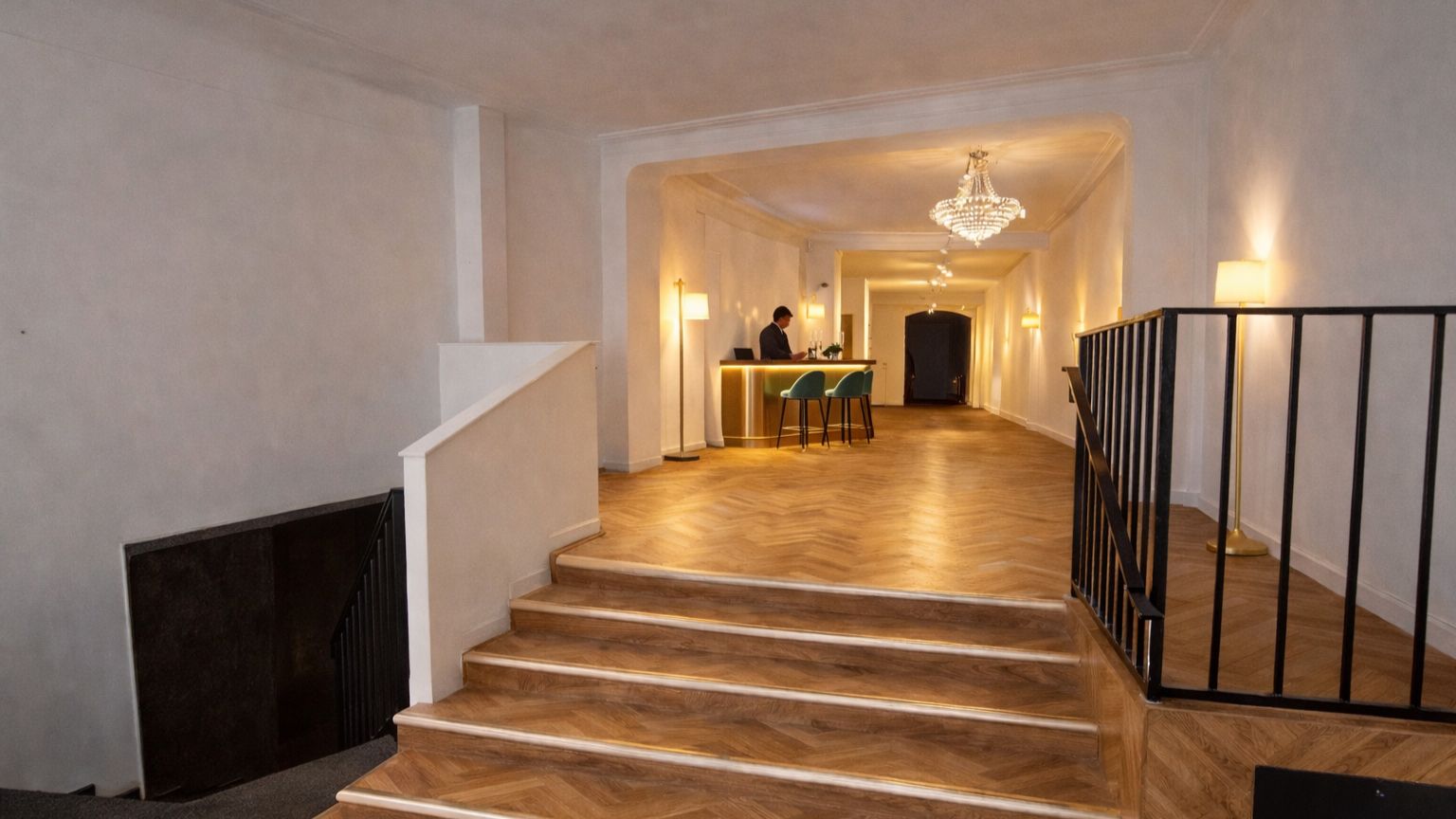 Marmorgulve og elegante lysekroner i loftet. Et skrivebord med lyse stolene. En person sidder og skriver. En søjle og et højt loft. Et mørkt område med en skorsten.