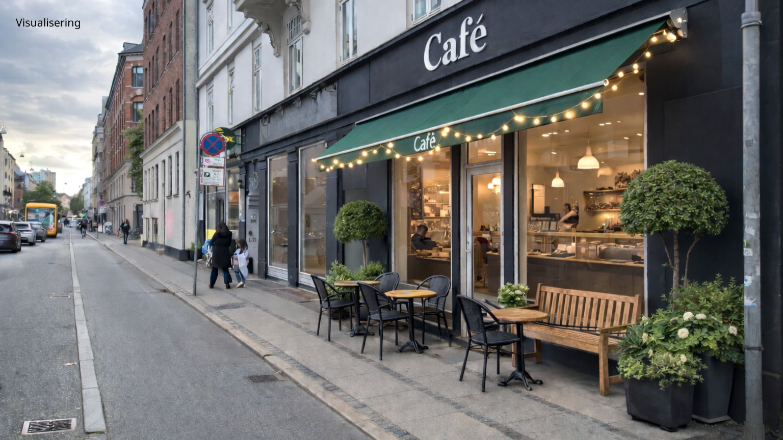 Stort café med indgangsparti, grønt markant og lysekroner i butiksvinduet, udenfor med træbænk og plantepotter på fortauet