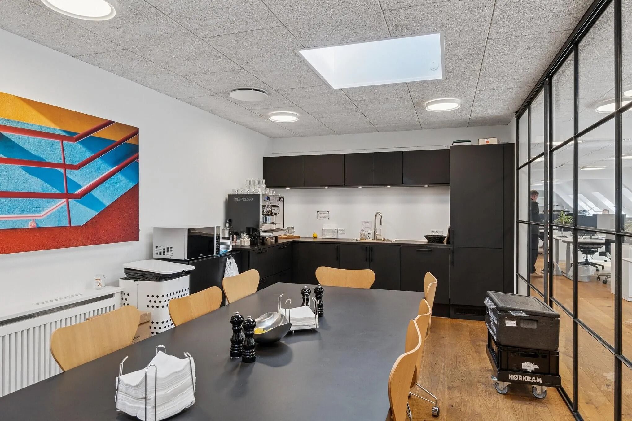 Kontorlokaler med køkken, mødesal og taghave. Køkken med kaffemaskine og mikrobølgeovn. Mødesal med langt bord og stole.