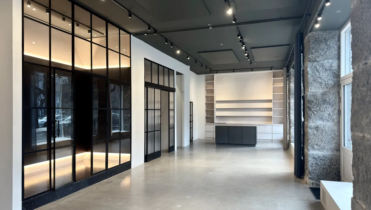 Erhvervslejemål i stueplan med moderne glasvinduer og loftslamper. Køkken med møbler og loftsvindue samt højt hængende lysekroner.