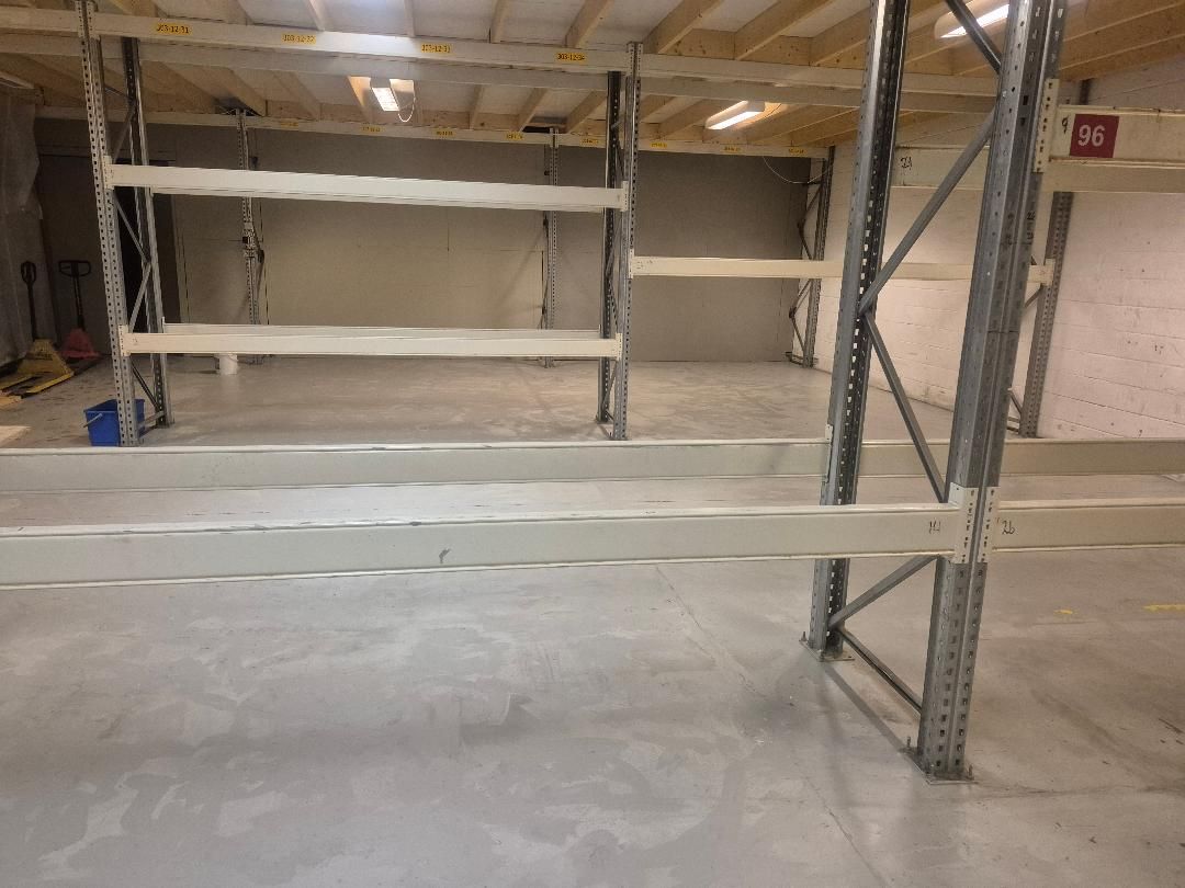 Lager med store højde og bredde lejes som industrilejemål på Hammerholmen 46, 2650 Hvidovre. Høje lagerhylder med skråtag til palleløfter. Lys i loftet.
