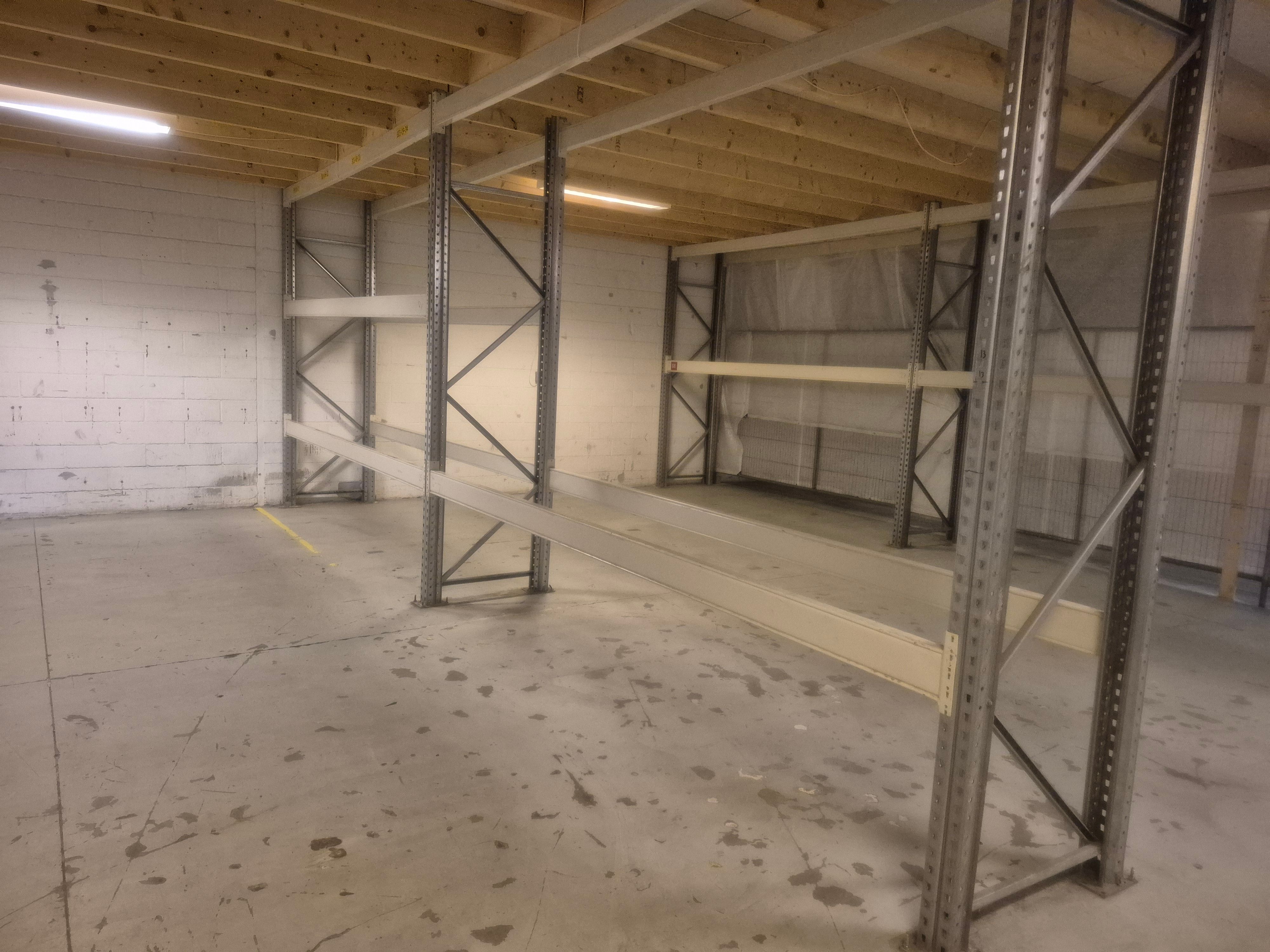 Lagerlokaler med højloft, hvor der er et stort lagersystem med stålstel og tom plads på gulvet