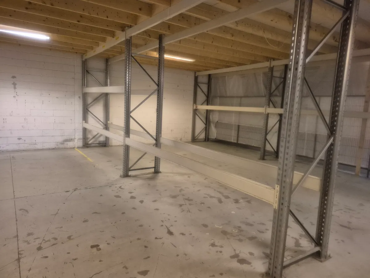 Lagerlokaler med højloft, hvor der er et stort lagersystem med stålstel og tom plads på gulvet