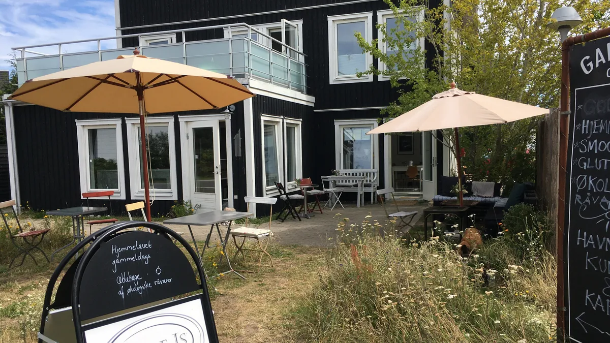 Hjemmelavet gammeldags hyggeligt køkken med terrasse og parkeringsplads, udendørsborde og parasoller