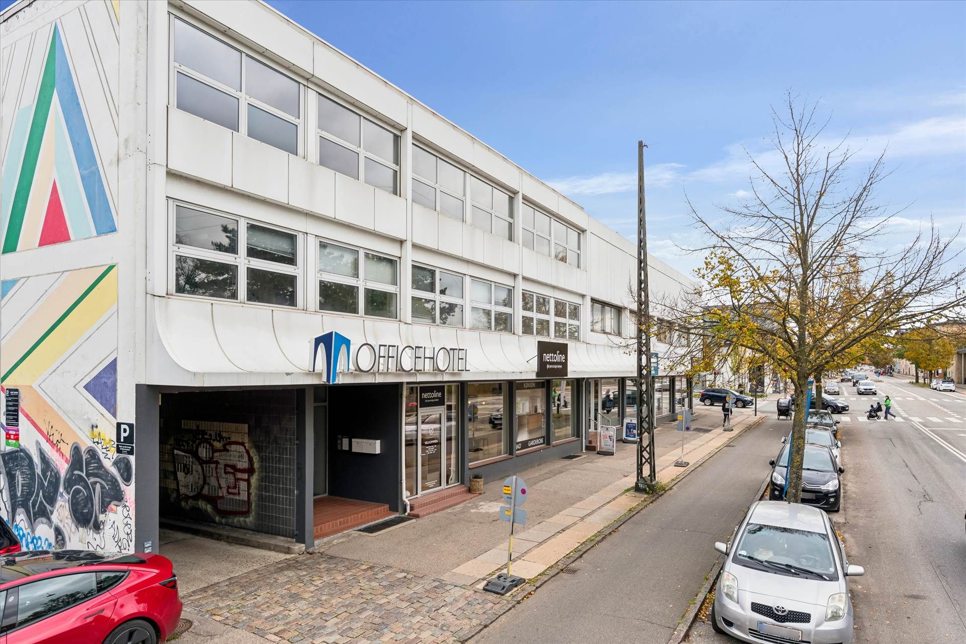Kontorlokaler med store ruder og flotte farvede væggen og en stor graffiti ved Husumvej og Frederikssundsvej.