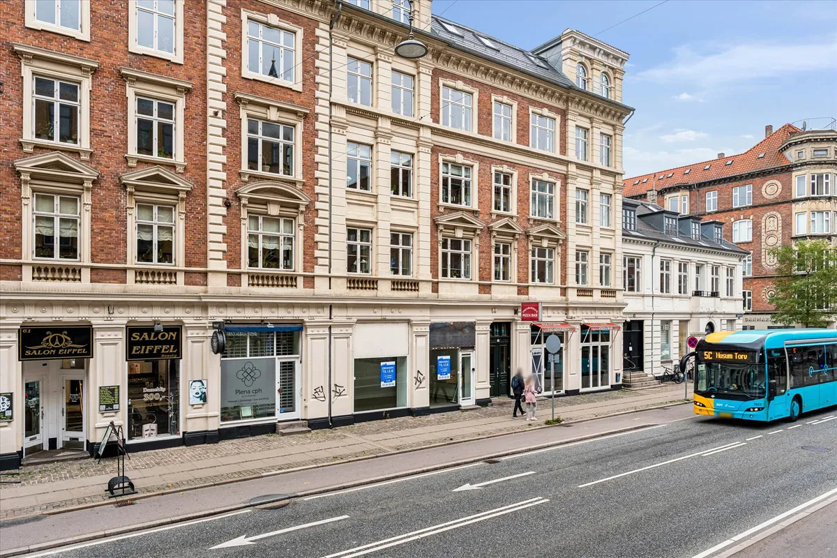 Butikslokaler med Salon Eiffel og salon på Amagerbrogade i København med bus og gågade foran