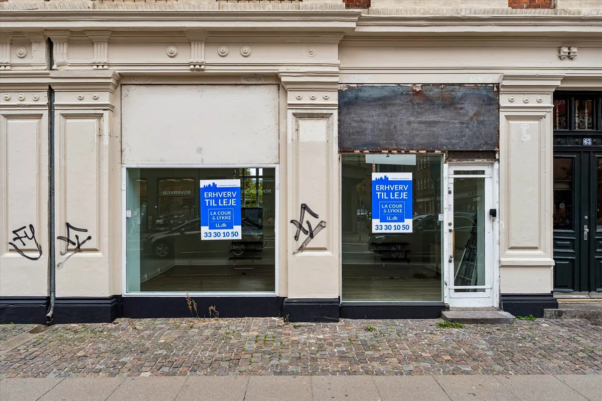 Butik med udsalgsvindue med skilte og åbent indgangsdør med nummer 63