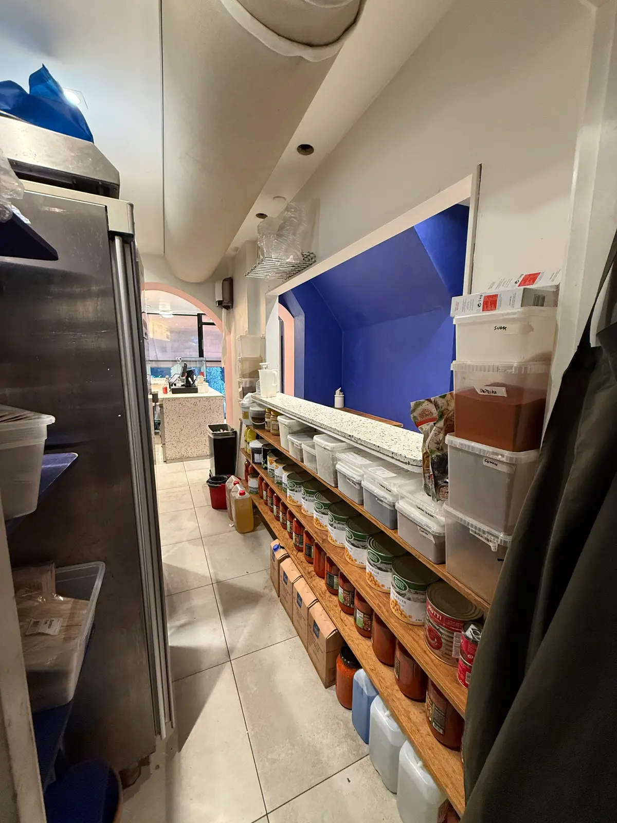 Køkken med flere hylder og emballagemateriale, der er opbevaret på hylderne og på gulvet